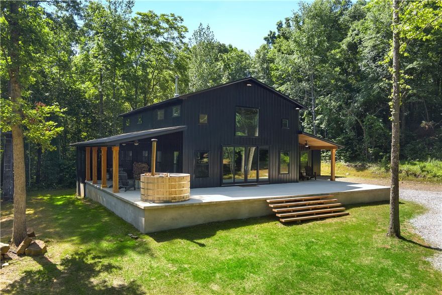 Spectacular newly built home on 125 acres of pure Ozark Mountain bliss!  Two live creeks flow on this wooded property that is situated only 35-40 min from the home of the Hogs in Fayetteville! Completed in 2022, this beautiful home is nestled in the middle of the acreage amongst large hardwoods away from the hustle and bustle of the city!  The property is located on an amazing road of well maintained, but spread out "neighbors" and provides plenty of solitude. No city lights, no road noise.  Just the sound of creeks and wildlife including turkey, deer and more!  The covered patios + wood burning cedar hot tub will be an oasis for relaxation & entertainment. This property boasts miles of great trails for hiking, riding UTVs or Mtn Biking.  It also adjoins the National Forest!  A 32x32 shop has room for cars and toys or could be converted to an extra bunk house for more guests.  The pics of this home speak 1000 words but a few highlights include the double primary suites, stunning kitchen + great room.  A must see!