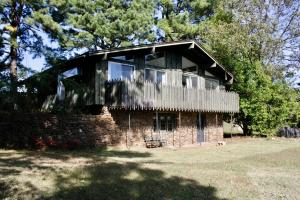Step back in time in the best possible way with this well maintained one owner home. This is a mid century home with every detail falling into line with the styling from that time. If midcentury modern is what you are looking for don't let this pass you by. The main floor has vaulted ceilings and an entire wall of windows that keep this home feeling light and airy You can walk out onto the deck and enjoy a beautiful view of rural Arkansas.. There is also a walkout basement that is finished on one side with the master suite and has a workshop area as well. From the basement is a secluded outdoor area that is absolutely perfect for cook outs and get togethers. Schedule your showing for this today.