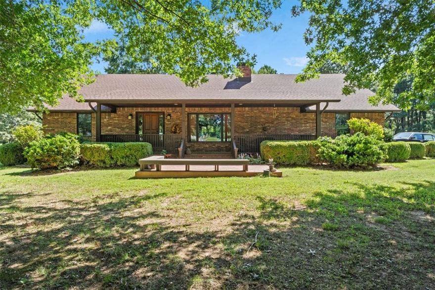 Just steps from Lincoln Middle and Elementary, this well-kept 2,062 SF home sits on 10 acres. Inside, you’ll find an open floor plan with custom windows, flooring, and cabinetry, plus a living room anchored by a striking natural stone fireplace. The kitchen features knotty pine cabinets and a stairway leading to an upstairs bedroom. Both covered porches have brick flooring and railings—the front opening onto a spacious wood deck, the back outfitted with a ceiling fan for relaxing evenings. The property also includes a 660+ SF mother-in-law suite or rental, along with a 16x24 storage building and a 10x24 covered side shed on concrete. Mature trees and a great lawn complete this rare find, which also offers a prime spot for residential development. Ecowater, Water filtration system in the main house to convey.