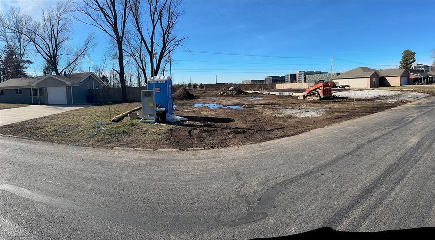 Currently under construction, this sophisticated three-story single-family attached home offers elevated design, premium finishes, and an exceptional location backing onto the Walmart Home Office and Bentonville’s renowned trail system. This thoughtfully designed residence features 3 bedrooms, 2.5 baths, and an attached garage, blending modern functionality with upscale comfort. Interior highlights include Cabira Quartz countertops, premium KitchenAid appliances, a stylish fireplace insert creating a warm focal point in the main living space, spacious walk-in closets, and an open, light-filled layout ideal for both everyday living and entertaining. Located in the heart of Bentonville, this home offers effortless access to walking and biking trails, dining, shopping, and the area’s vibrant arts and culture scene. A rare opportunity to own new construction in one of Bentonville’s most desirable locations—where modern luxury meets Bentonville living.