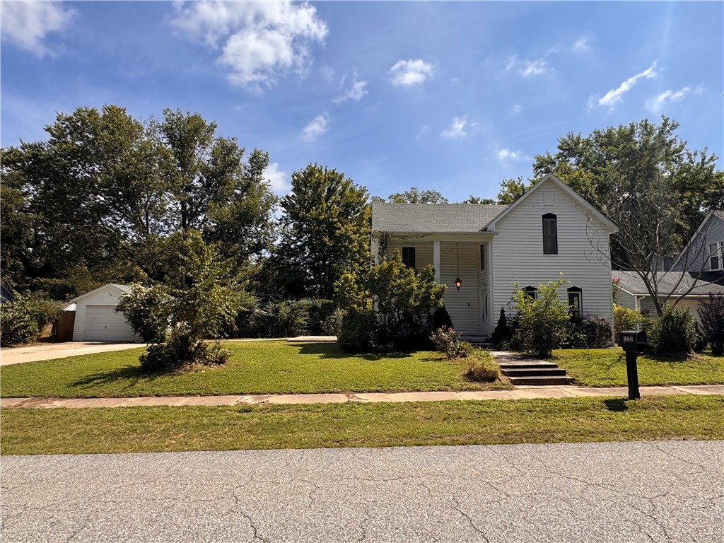 Charming historic home in the heart of Sulphur Springs! Built with craftsmanship and character, this spacious 2123 sq. ft. residence offers 3 bedrooms, 3 full bathrooms, and 2 generous living areas. The large kitchen and family room combination creates a warm and welcoming gathering space, complemented by a cozy fireplace. The property sits on a large, park-like lot (0.34 acres) with mature trees, lush greenery, and plenty of open lawn space. Enjoy multiple outdoor living areas including a classic two-story covered front porch, a side patio, and a spacious covered back patio perfect for relaxing or entertaining. Practical features include a detached garage, as well as a combined metal carport and storage room for added convenience. This property is being sold as-is making it an excellent investment opportunity. Located just 30 minutes from Bentonville and only 8 minutes from Gravette schools, this home offers small-town charm with easy access to modern amenities.