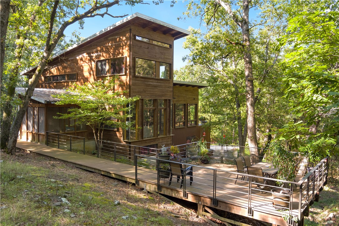 ruly one of a kind property in Northwest Arkansas! Rustic contemporary architectural masterpiece w/ over 100 stunning acres & 1140ft White River frontage. Expansive windows provide 360° tree house views from all 3 levels & natural materials incorporated throughout seamlessly fuse the exterior setting + interior design. You'll love the built-in's, floor-to-ceiling doors, bar lounge, floating staircases, duel master bath en-suites, soapstone counters & listening to the wet weather creek from one of your many decks/patios/hot tub. 2400SF (60x40) shop (not incl. in house SF) w/work bays, 1 bed/1 bath guest home + additional 800SF upper level storage. 3 cedar closets. Extensive trail system w/strictly managed wildlife for nearly a decade. Established food plots + stands for duck/deer hunting. Pole barn. Planted rice & soybeans. Fishing & Recreation. Property adjoins the Lake Sequoyah Park. Luxury rural oasis w/NWA at your doorstep- 20 MIN to downtown Fayetteville, 50 MIN XNA/downtown Bentonville. Fayetteville schools