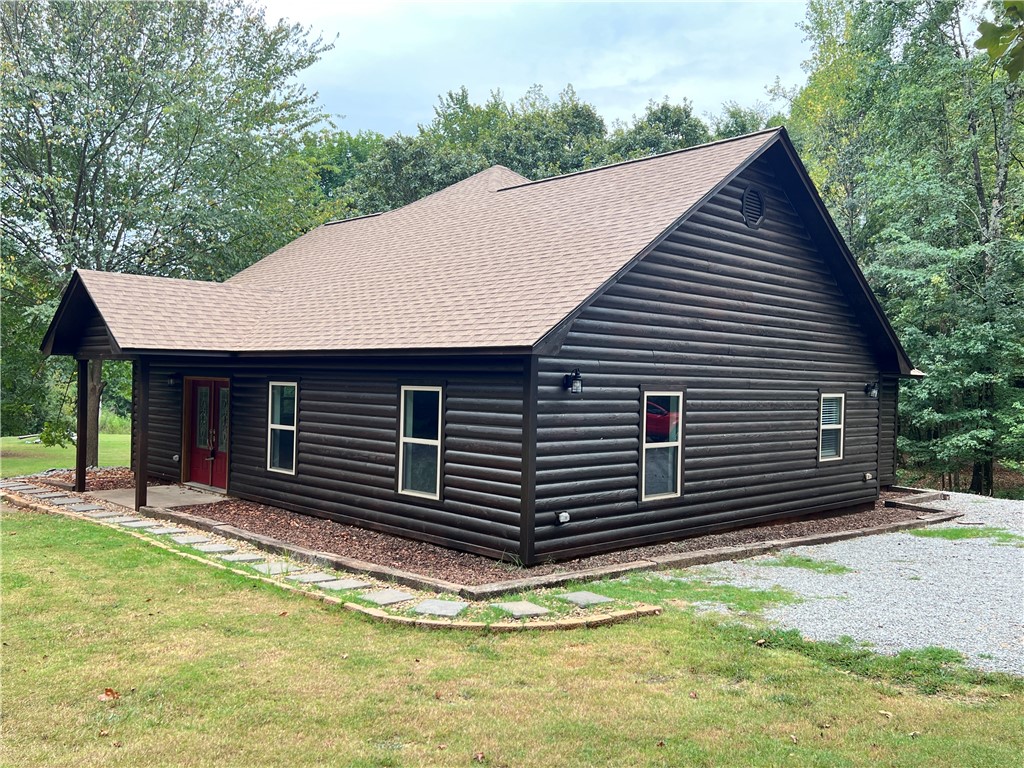 A well built 2400 square foot home on over 16 acres, just outside of Russellville city limits? Act now and be rocking on the back porch this fall! Enjoy country living with plenty of land for privacy and a wrap around porch that provides a gorgeous view! In addition to the Log sided, 3 bedroom, 2 bath house, this property also comes with a 30x40 shop! This metal building shop is equipped with full bath and living quarters when additional space is needed. The RV and tractor parking canopies both convey and the equipment can be purchased separately. Each building comes with a refrigerator and a washer & dryer set. New roof in August of 2025!
