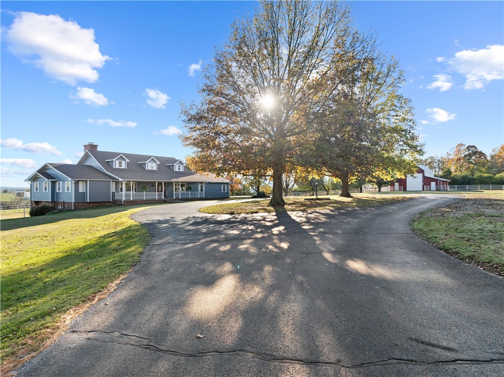 This stunning executive-style home in Harrison, AR, near the Buffalo National River and just 30 minutes to Branson, MO, offers luxury housing 77 picturesque acres. The chef's dream kitchen features granite counters, Frigidaire commercial-style stainless steel appliances, a gas range, wall oven, and custom cabinets with smart features for seamless meal prep. With 6 bedrooms and 5.5 baths. The home is ideal for multigenerational living, including a second full kitchen, 2 bedrooms, and 2 baths in the basement with ensuite baths. Two wood-burning fireplaces, one ducted into the HVAC system for added winter energy efficiency. Enjoy sunsets over the Ozark Mountains from the deck, and raise livestock on the 77 acres. You can store your RV in the red barn with 14-ft. doors for direct pass through. Located just outside the city limits, this home is only 2 minutes from the Creekside Regional Community Center, making it a perfect blend of rural serenity and modern convenience.