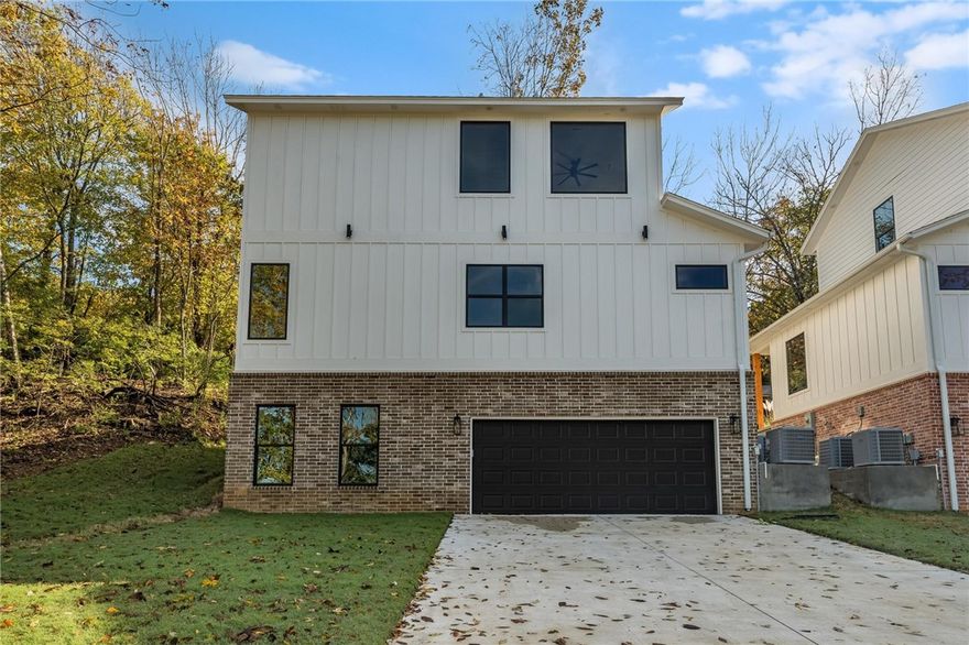 Perfectly situated on the right side of the property at the corner, this newly constructed home is located just a few miles from the University of Arkansas and showcases exceptional craftsmanship throughout. Offering four bedrooms, each with a private ensuite bathroom, this residence features luxury details including tinted Weatherbarr windows, granite countertops, Frigidaire Professional appliances, Fanimation ceiling fans, and Delta fixtures. Built for efficiency and comfort, it includes a two-stage HVAC system, insulated walls and floors, and premium engineered wood flooring with carpet in the bedrooms. The walkout basement opens to an oversized two-car garage and a large driveway, providing ample parking for guests on game days. Surrounded by wooded areas on three sides with beautiful sunset views and frequent deer sightings, the property also features poured stem walls, French drains, a front patio, and custom exterior lighting on an automatic timer. One-year builder warranty included, schedule your showing!