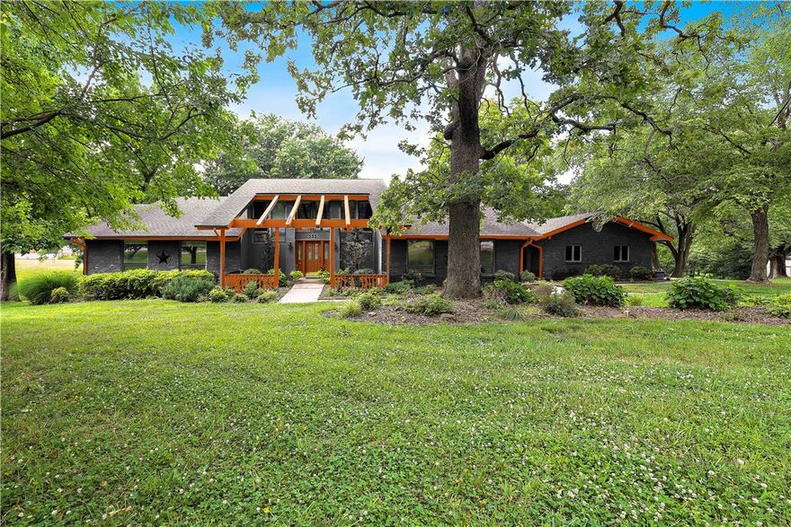This stunning property is located in the heart of Downtown Bentonville, offering a park-like atmosphere
and spanning across an impressive 3.98 acres. The prime location provides an exceptional opportunity to
walk and bike to downtown shops, restaurants, as well as renowned attractions such as Crystal Bridges,
The Momentary, the Razorback Greenway, and more. The lush landscaped front and back yard showcases
the beauty of the surroundings, making it one of the most picturesque properties in the area. The
panoramic views afforded by the floor to ceiling windows are truly breathtaking. For those who enjoy
entertaining, this house offers a formal dining room with skylights, a billiard room and a media room,
complete with comfortable theater seating. Beyond the main residence, this legacy estate also includes a
detached workshop that offers tremendous potential.