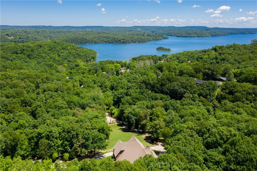 Incredible 14 acre Ozark Estate located in Northwest Arkansas overlooking beautiful Beaver Lake. Throughout the property you will find native dog wood trees, soaring oaks, wet weather creeks that create mini-waterfalls and abundant wildlife. The main home is over 4200sqft of elegance with soaring 20ft ceilings and amazing wood work. This home has multiple advantage points for you to enjoy the views including a private alfresco dining porch off the kitchen. The other great space to relax and enjoy is the screened in morning porch off the master suite with hot tub and outdoor seating under the pergola. The majority of the main house was remodeled over the last 2 years.  The property also includes a “Barn-ominium” which makes the perfect workshop or man cave. It includes a 1,000sqft of living quarters finished in a modern rustic feel with wrap around deck and screen patio area. This is true Ozark Estate located minutes from the marina, museums, restaurants and more.