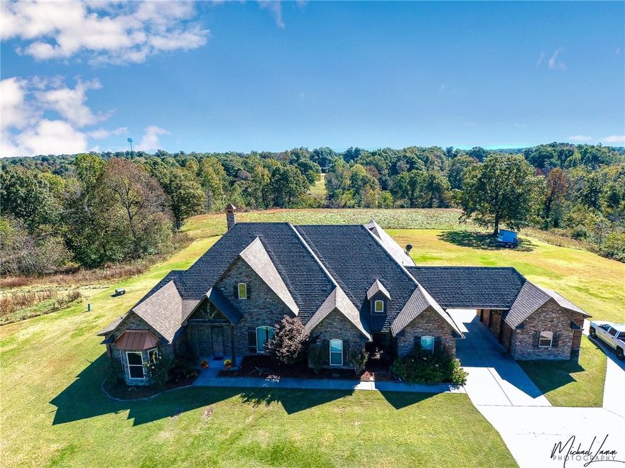 Private entrance to 20 acre secluded homestead.  Home features a wonderful kitchen, media room, stainless appliances stained concrete and ceramic flooring, hardwood flooring, granite countertops, oversized utility room, multiple built ins, outdoor patio fireplace and TV hookup.  Large 4 bay garage with overhead doors, RV storage and full size basketball court.  This property features endless views sitting in the middle of 20 acres, all just minutes from lake Wedington and I-49!