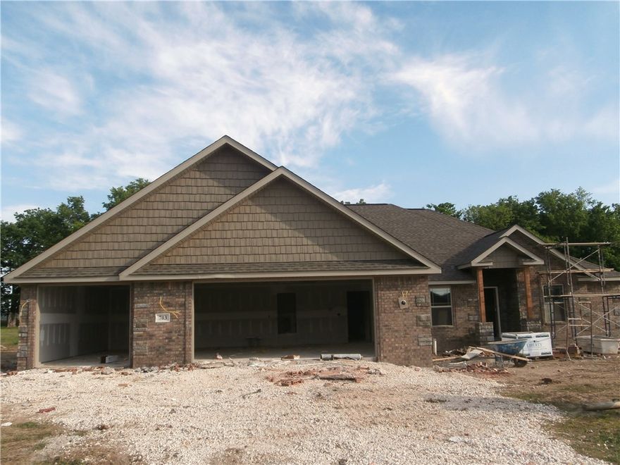 New construction home in Prairie Grove. All the bells & whistles- granite counter tops, wood & tile floors & gas log fireplace in living room. Tall ceilings in the living room, kitchen, dining & master bedroom, speak easy front door, dual vanities plus a whirlpool tub & separate shower in the master bath & more are all located in a great open floor plan with split bedrooms. Outside is a large patio with a wood burning fireplace & tv hook up. Trees behind lot for shade.
