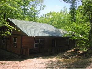 New well built, log sided 3 bedroom/2 bath home that sits above Shop Creek on almost 14 acres. Close to pavement for easy access but very secluded. Large deck above creek. Mostly wooded with lots of wildlife. Central air and heat with a wood burning stove. Great new well on property. New Workshop/garage. Property touches county road. Newton County seclusion at it's best.
