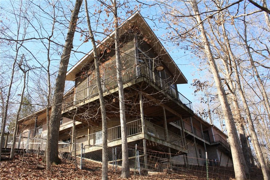 Welcome to your private retreat in the trees!

This one-owner, single-family home sits high among the treetops, with stunning lake views from every angle—truly your very own treehouse escape. Enjoy the beauty of nature, from the sights and sounds of the surrounding wildlife to the peaceful rhythm of the water below.  Just a few of the many features offered by this property include an upstairs electric fireplace insert, downstairs wood-burning fireplace/wood stove, washer/dryer hookups, whole-house generator hookup, RV parking, 2 outbuilds: woodshed, tractor outbuilding, a beautifully crafted built-in pantry with abundant storage, and a 3-slip dock with one lift. A rare combination of serenity, privacy, and natural beauty combine to make this a must-see property that you’ll need to experience in person to fully appreciate.