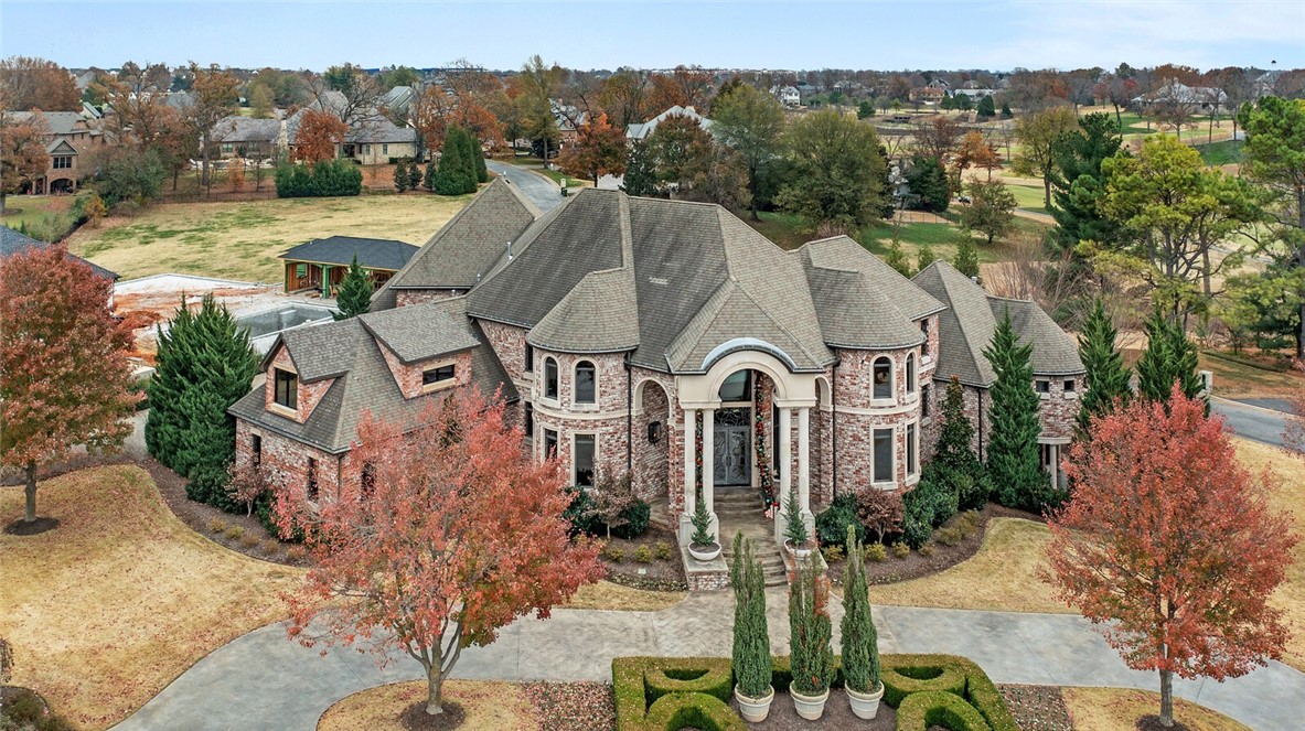 Lavishly appointed contemporary home in Pinnacle Country Club. This home has it all - Floor-to-ceiling windows throughout, a custom designed kitchen with multiple islands, wine cellar, private office, home theater, exercise room, and a library loft. Privately located on the main level is the primary suite, featuring a gorgeous dome ceiling, double sided fireplace, and a spa-like bath with soaking tub, walk through shower, designer walk-in closet, and attached laundry room. Second level features large secondary bedrooms with private baths and walk-in closets, bonus room, separate additional laundry room and loft areas. Basement level hosts a theater room with kitchenette & bar space, wine cellar & private secondary suite The backyard oasis is perfect for entertaining with expansive covered outdoor multi-level decks & patios flanked by a heated resort style pool, spa & outdoor kitchen & even a sport court/basketball court! 4 car + golf cart garage - zoned for Bentonville Schools.