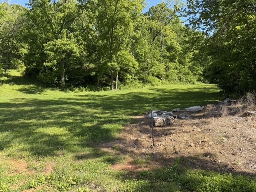 Discover a rare opportunity to own 11 +/- acres of prime land with beautifully adorned walnut tree lined road frontage. Approx 3 +/- flat cleared property that slopes up toward a serene wooded area providing a perfect blend of open space and natural seclusion. Located just minutes from downtown Rogers, you can enjoy the convenience of urban amenities while retreating to your peaceful oasis away from the hustle and bustle of city life. Water and Electric are readily available at the street, making this property an ideal canvas for your dream home. Don't miss your chance to secure this unique piece of land in a tranquil setting!