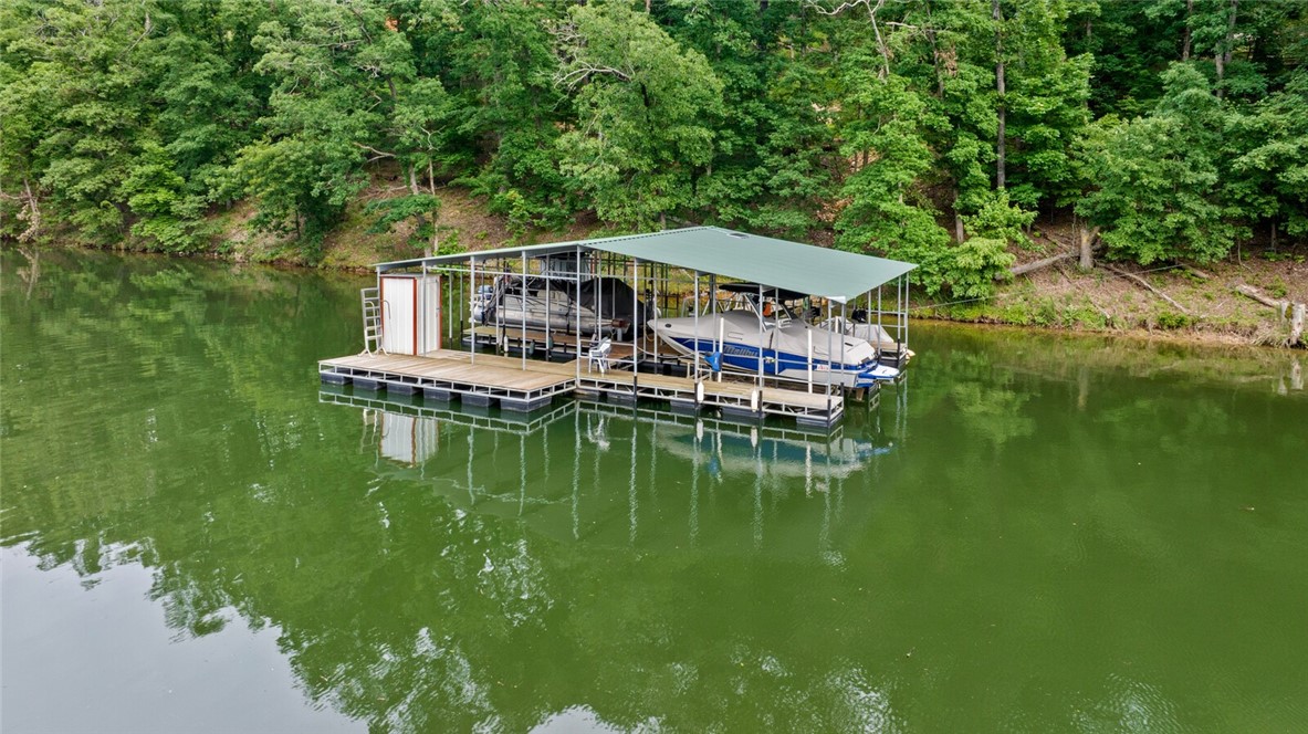 Your Beaver Lake Retreat Awaits! 15+ Acres with a 10'x24' boat slip in a 4-slip co-owned boat dock in Little Coose Hollow Cove with adorable cabin on-site and ready to go! The 400sqft cabin features a kitchen, living room, full bath, two lofts and has electric and septic on site. So many options on this 15 acres... continue to enjoy the cabin on the upper 10 acres, build alongside it or build on the lower 5 acres and enjoy the gorgeous view of Beaver Lake. Take a short ride down the dock on a side-by-side & enjoy 500' of Corp frontage with steps accessing dock and enjoy fishing, boating or relaxing on the swim deck. Don't forget to enjoy all of the wildlife! This is a great hunting property as well.