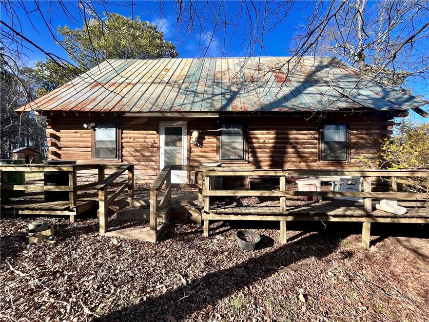This fixer-upper log home on 38 acres offers endless possibilities! With over 4 acres of fenced and cross-fenced pasture, it's perfect for livestock as well as outdoor activities. Approximately 33 acres of mature hardwoods and pines provide excellent hunting, ATV riding, and more. The area is abundant with deer, turkey, bear, and small game. The property includes both well water and city water for convenience, along with two ponds, a barn, and a workshop. Whether you're looking to restore the log home or build your dream house, this property offers the space and serenity of country living.