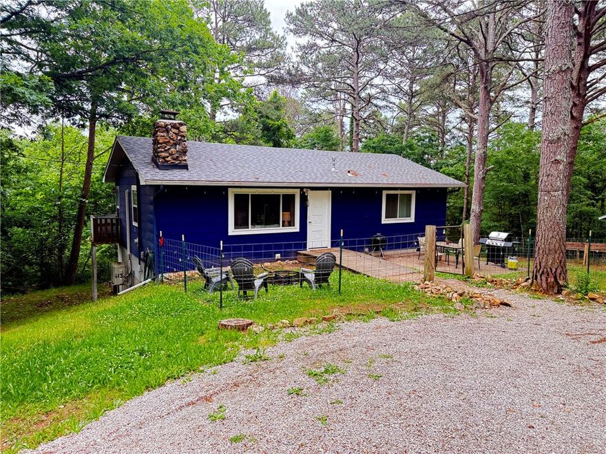 Secluded 2BR/1BA home on 5.86 acres just minutes from downtown Eureka Springs. Newly renovated main level with open floor plan. Stone wood-burning fireplace in the living room. An island separating the living and kitchen/dining areas. Two spacious bedrooms and a full bath with a tiled walk-in shower and double vanity.   An additional 960 square feet of unfinished space in a walkout basement with a concrete floor, windows, and a door to the backyard. Great space to finish out for more living or use as a workshop or studio.  Additional storage in an 8'x9' outbuilding. Fenced yard around the house for pets. Outside city limits, so it could be used as a short-term rental.
