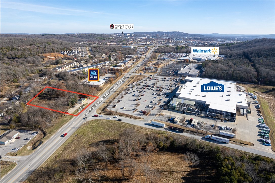 Commercial property along W MLK Jr. Blvd in Fayetteville! Minutes to I-49 and the University of Arkansas. Property backs up to the newly constructed Centennial Park. Income producing or has potential for redevelopment.
Approx. 232' of frontage on W MLK Jr Blvd with 44,000 CPD. Superb visibility near major retailers, including Lowe’s, Walmart and Aldi. Current lease generates $2,940/month, increases 5% annually through 2027. Building has new roof, AC, gutters, and siding. Development concept plans available upon request.