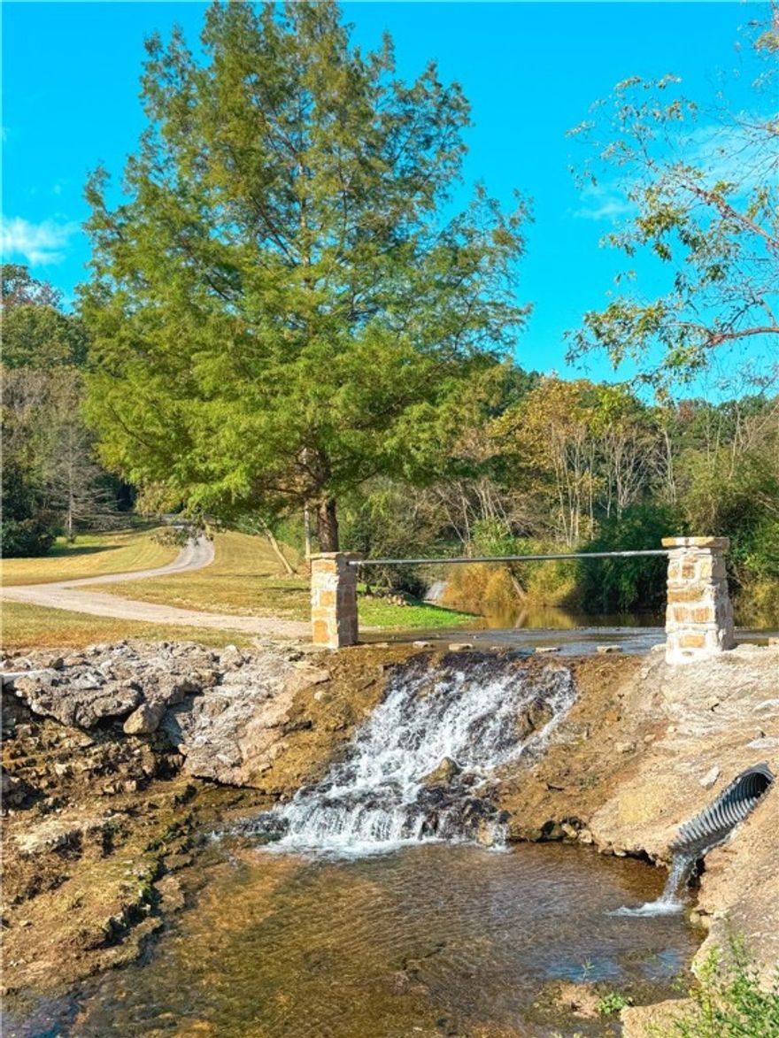 Welcome to your personal paradise! Sit outside on the patio and listen to the waterfall flow and watch all the wildlife roam.  This beautiful home sits on 6.76 private acres with 2 ponds, a year round creek running through it, mature walnut and pecan trees and fruit trees . Property has an outbuilding/barn and an attached insulated workshop with a half bath. The home has 2 living areas, a loft that was converted to a 4th bedroom or a great playroom, newly remodeled master bedroom with custom closet and newly remodeled 2nd bedroom. The home has 2 HVAC units, one being an energy-efficient Geothermal unit, installed in June of 2022 and a new Electric unit installed in June of this year. Other upgrades include a new roof, new gutters, new well house and all new well equipment, new LP smart siding, just to name a few.   A full list of upgrades is attached.  Interior photos to be added soon.