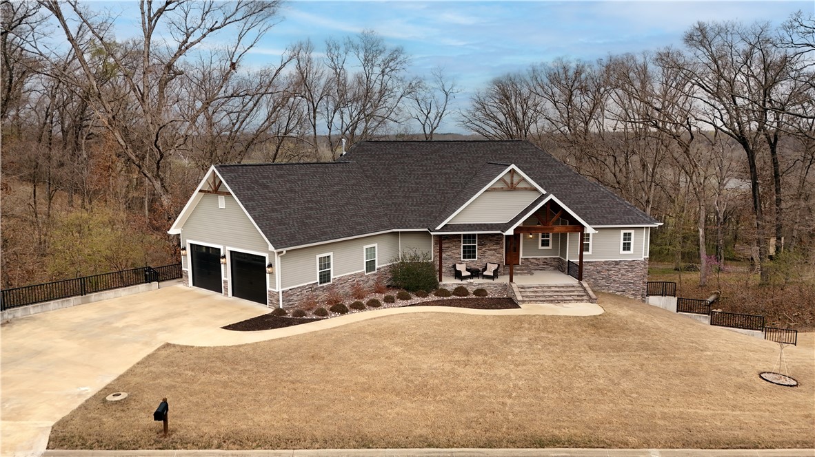 Your amazing new home is a lovely country estate within walking distance of gorgeous City Lake Park and miles of beautiful trails. You'll love the seasonal view of Siloam Springs Lake from the bright wall of windows in your large, wide open kitchen/dining and living space with soaring cathedral ceilings. Your home is designed to fill with friends and family with a second living area downstairs and a huge bonus room. Need some privacy? The primary bed/bath, separate in-law suite, and third bedroom w/attached bath on the main floor, plus three more big bedrooms in the lower level, give everyone space for some me-time. Cozy up to your stone fireplace in the winter, and let the party spill out onto the two enormous decks all year round. 3 HVAC units keep your 4000 sqft home cool or cozy, no matter the season, and every nook and cranny boasts tons of storage space, including a garden garage in the basement, perfect for storing all your outdoor tools and toys. Schedule your tour of this peaceful new lifestyle today!