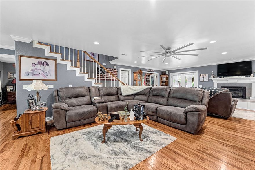 Discover this charming country farmhouse style home nestled on five wooded acres in the desirable Prairie Grove area. This spacious 3-bedroom, 3-bathroom home offers approximately 3,700 square feet of living space, complemented by a beautiful, recently remodeled kitchen (2021) featuring double ovens, a built-in freestanding ice maker, and a refrigerator that conveys. The home boasts real wood flooring throughout and two primary bedrooms, ideal for flexibility and privacy. Enjoy the privacy and tranquility of your surroundings while relaxing on the expansive 1,500-square-foot covered wrap-around porch—perfect for outdoor entertaining. Additional amenities include a heated and cooled 864-square-foot metal building (not included in the total square footage), perfect for a workshop or storage, and a long driveway lined with 25 exterior lamp posts that enhance the property's charm and security. The property offers the perfect combination of modern comforts and rustic appeal in a serene, wooded setting.