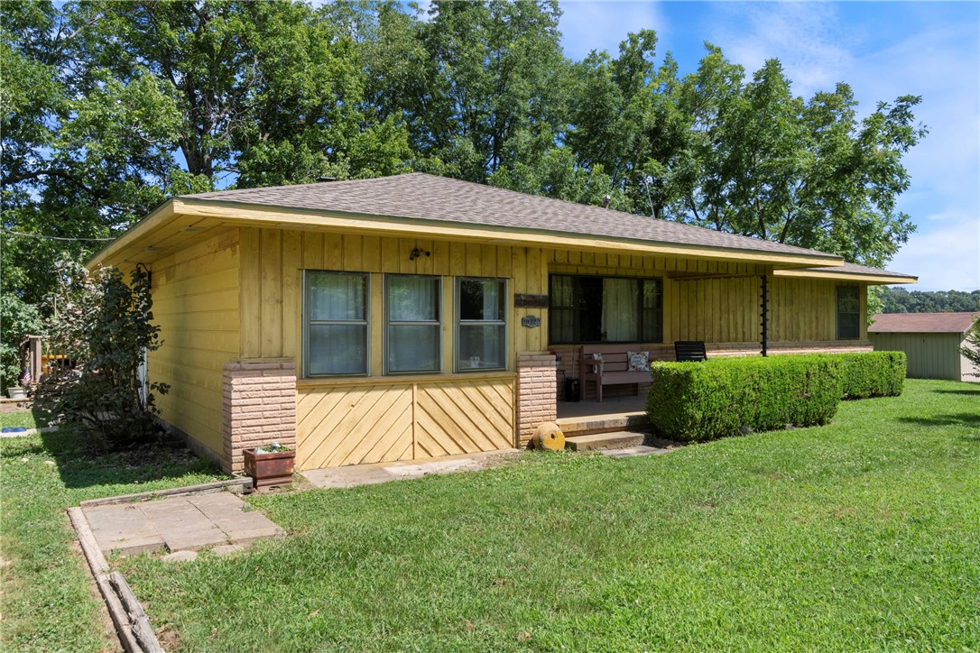 Experience the charm of country living in this beautiful farmhouse-style ranch on 4.25 acres in Gentry. Surrounded by scenic views, this 3-bed, 2-bath home offers peaceful seclusion just 15 minutes from all that NWA has to offer. Enjoy an updated eat-in kitchen with granite countertops, stainless steel appliances, including a double oven and ample storage throughout. The spacious primary suite features a large walk-in closet, double vanity, and jetted soaker tub. Updated wood laminate flooring runs through large, light-filled rooms. A bonus space with built-in cabinetry is perfect for crafts, hobbies, or a home office. Step onto the expansive deck to unwind and take in the picturesque countryside. The property features established garden areas, mature landscaping, and plenty of space for a farm with no restrictions. The 24x32 detached garage/workshop adds functional space. This is your chance to own a private retreat with room to breathe!