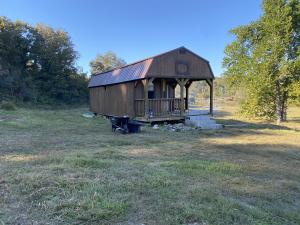 Check out this unfinished 14'x32' Derksen lofted barn cabin and 12.83 Acres M/L with most of the land being in fenced pasture. The cabin has two lofts, electric, rural water, and a covered porch, The land has two ponds and a hunting area by one of the the ponds. The cabin does not have a bathroom or septic. This is a must see for a private tiny house cabin with acreage.