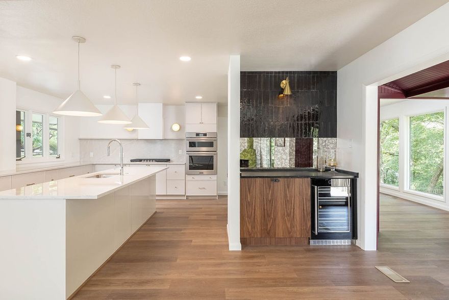 Beautifully renovated mid-century home sitting on top of Mount Sequoyah with treehouse views on a flat, walkable street.   It features an expansive kitchen with an adjacent beverage bar and soapstone countertop. The sunroom is a great dining area located just off of the kitchen. There are two large living room spaces each featuring fireplaces. The rooms are flooded with natural light and scenic views.  
Enjoy secluded backyard views from two decks or sit by a fire pit under more than 100 string lights.  
It is a downhill walk to Root Elementary with close access to the University and the downtown historical district.