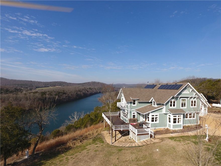 Craftsman style house built by a true artisan. White River/Table Rock lake views from nearly every room of the spacious designed home. Perched high above the famous White River, this home has custom wall built-ins, gourmet kitchen with double oven and granite countertops, hardwood floors, vaulted ceilings, and custom iron work. 12 large solar panels on roof! Huge upper floor master suite with 2 private balcony decks. Library, office, & ADT security. Large workshop, storage building, and vintage wooden barn.