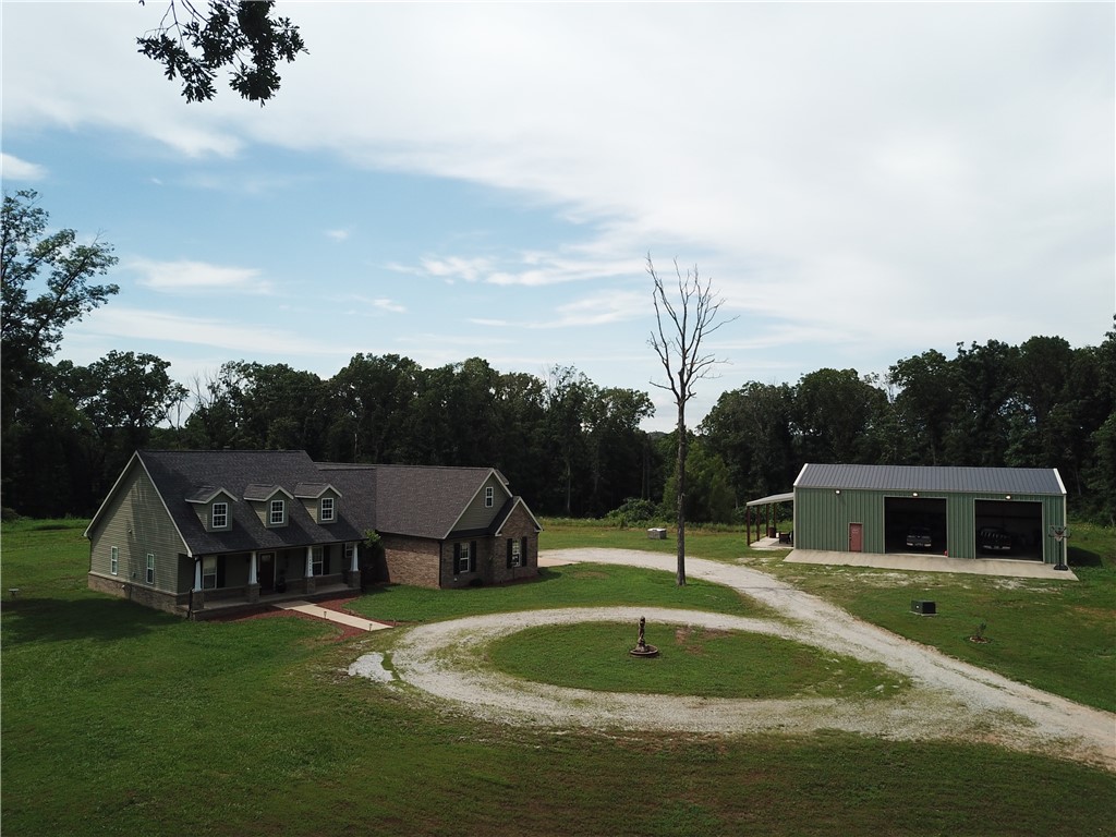 Privacy and seclusion but easily accessible to all of Northwest Arkansas! This 15 acre estate has been partially cleared but also has plenty of trailed wooded areas to explore. This beautiful farmhouse style home has engineered hardwood floors throughout. The stylish kitchen has tons of storage, granite countertops and stainless steel appliances. The primary suite is spacious and has a built in safe room! Outside, enjoy the expansive 40x60 detached shop with two bay doors, an overhang, and the potential to add a second living area—ideal for workshops, hobbies, or additional dwelling space. The property invites outdoor living with garden areas, walking and ATV trails, and endless opportunities to explore and relax. Don’t miss out on this incredible opportunity—schedule your tour today before it’s gone!