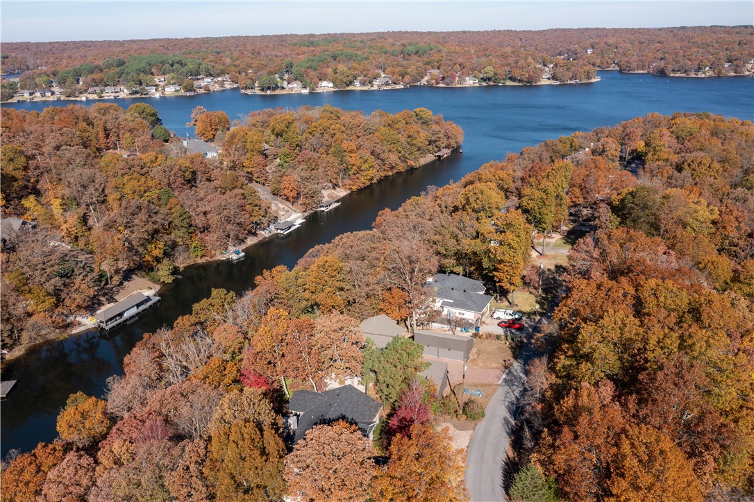 Stunning lakefront retreat on coveted Loch Lomond! This exceptional Bella Vista home offers breathtaking water views, modern updates, and a private dock for boating, fishing, or relaxing. Enjoy a treehouse-like feel from the expansive deck overlooking the lake. Recent upgrades include a luxurious $20K master bath remodel (2024), new recessed lighting, a brand new seawall, interior/exterior paint, a new garage door/opener, and smart security with a Nest system and outdoor cameras. A 3 year old roof (installed October 2022) adds long-term value. Inside, natural light fills the airy living spaces, maximizing stunning lake views. Whether a permanent home or a peaceful getaway, this retreat offers the ultimate lakeside lifestyle. Don’t miss your chance to own a slice of paradise on Loch Lomond. Schedule your private tour today and experience the magic of lakeside living firsthand! Back on market due to absolutely no fault of the seller.