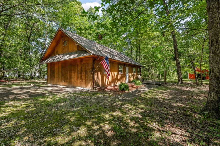 Unique cabin in the woods on a lovely 2.9 acre tract, offering rustic charm & seclusion. Originally constructed as a temporary residence during the building of a dream home, the cabin captures the peaceful spirit of country living. The septic system is designed for three bedrooms, giving plenty of flexibility for future expansion. Whether you envision constructing a new home or simply wish to enjoy the natural tranquility, this property offers it all. A striking red metal barn with six stalls—set up previously for horses—stands ready for animals or storage. The barn measures 24x24 and features a loft with additional storage space. Centerton Water. Barn is wired but doesn’t have power to it. Inspections are welcome but sellers prefer to sell as is.