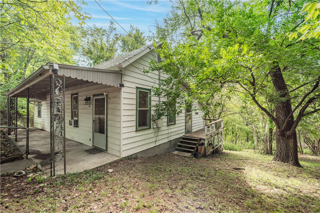 What's your Eureka dream idea? This cute fixer-upper with hardwood floors was once the Ozarkana Cottage, former home of a well-loved local musician and used as a music store and guitar repair shop. A real part of Eureka Springs music history! Zoned Quiet Commercial, this could be a quaint getaway, nightly rental, small cafe, or other business. Lovely garden spaces as well as your own private hollow teeming with wildlife, berry bushes and native plants. You will see deer, fox, rabbits, many birds and other wildlife here, right in the middle of town. Recently surveyed, four city lots are included and building additional cottages or shops is a possibility. Amazing location just across the street from Bubba's BBQ, Float Eureka Outfitters and Eureka Sweets Bakery. Arkansas offers a 40% tax credit on approved renovations in Eureka Springs. The possibilities are here, waiting for your vision.