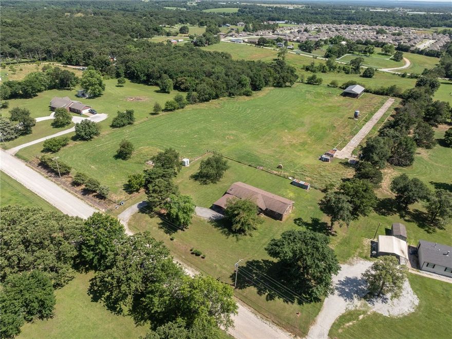 Don’t miss your chance to own a piece of paradise! This spacious rock farmhouse has 3bds 2 bath and almost 2,000sqft. Plus, it sits on this beautiful, fully fenced 7.47-acre property that would be perfect for horses, cows, and chickens. The possibilities are endless.. The home features a covered front porch and, open back deck.  It has two wells, both functioning and 1 with a new pump. Newer roof, carpet, windows, storm doors, insulation in attic, vapor barrier and insulation in crawlspace. New HVAC and water heater last year. Septic was pumped last year. Pasture is fenced on all sides, front yard is open. Located outside of Gentry city limits and only minutes to town, and main highways.
