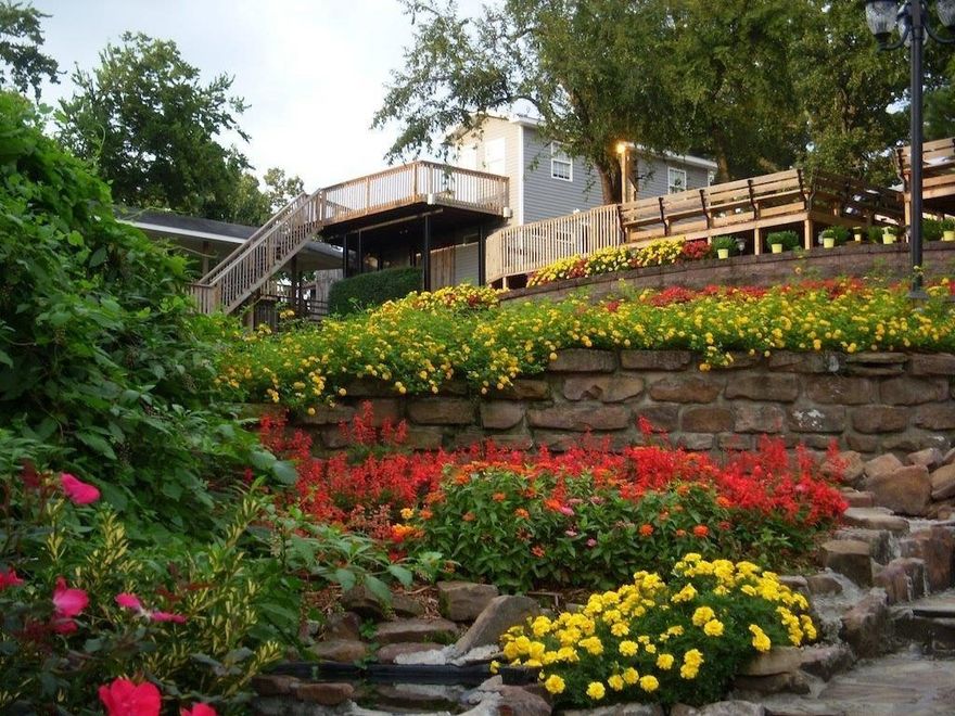 Directly across the street from the Donald W Reynolds Razorback football stadium, this iconic game-day destination is known & loved by all! Entire property consists of a 3-story residential dwelling with 1275-square-foot, double-sided RV garage at the base, a second 1521-square-foot home, private heated swimming pool, beautifully landscaped yard wired w/electric & cable, and 2 carports. Northwest Arkansas, ranked one of the Best Places to Live in America, is home to university & professional sports teams, world-class Crystal Bridges Museum of American Art, more than 200 miles of mountain biking and paved trails, & headquarters for Walmart, Tyson Foods, & JB Hunt. Driveway is shared with 410 N Oliver.