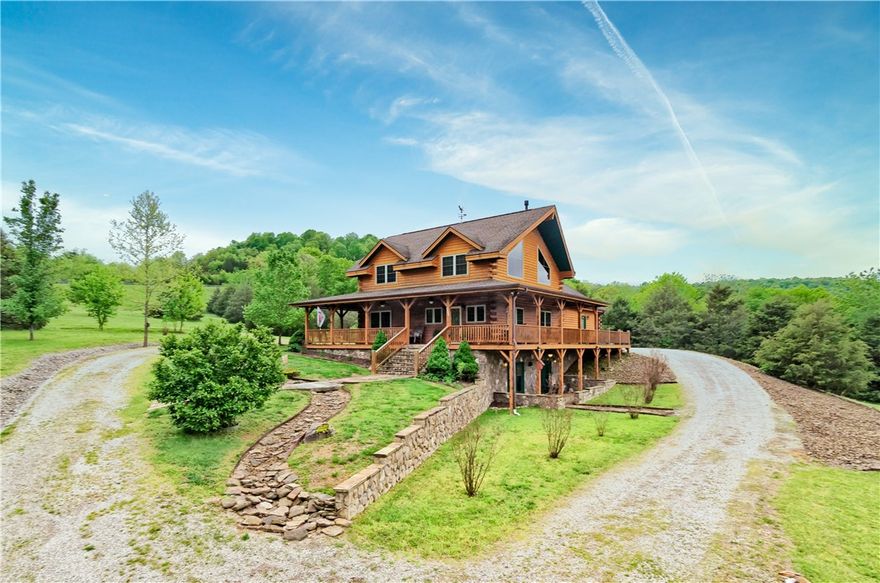 Welcome to this magnificent custom-built, locally-milled log home nestled on 12-acres, offering a tranquil retreat surrounded by nature's beauty.  Located within reach of the Kings River this home provides the perfect blend of rustic comfort, modern living, and outdoor recreation.
The open floor plan seamlessly combines the living, dining, and kitchen area which features modern appliances, ample cabinetry, and a center island.  The primary suite, located on the main level, offers an en-suite bathroom. The wrap-around porch provides an idyllic spot for relaxing, enjoying your morning coffee, or hosting outdoor gatherings. Immerse yourself in the natural surroundings and admire the peaceful pond, while the river beckons for fishing or water activities.  Additional features of this property include a three-car garage, fireplaces on both levels, a loft that can be used as an office or third living space, two storage sheds, and a storm shelter, generator and water softener for peace of mind.  Shared easement to river.