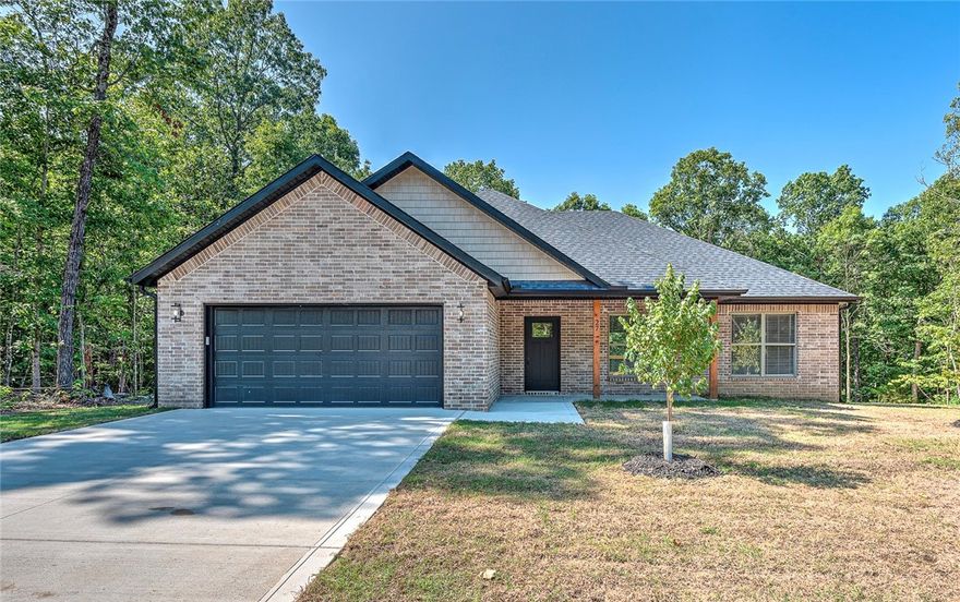 Seller offering $3,000 toward buyer’s closing costs! Pristine new construction in peaceful Bella Vista. This open-concept, split floor plan home showcases exceptional attention to detail. Natural light fills the interior, and both the front and back covered porches invite you to relax and enjoy the beautiful surroundings. 
Features include under-cabinet kitchen lighting & tile backsplash, upgraded 3cm granite countertops throughout, a spacious kitchen pantry, a mudroom hutch, and built-in shelving in the laundry room. The home is truly move-in ready, complete with blinds, gutters, and a luxurious tiled primary shower with a modern glass door. Even the oversized garage is finished with trim, blinds, and a super-quiet garage door opener with a built-in camera.
Don’t miss your chance to own a quality home in one of Northwest Arkansas’s most desirable communities - schedule your showing today!