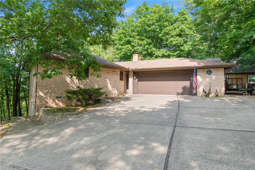 Nestled on 0.73 acres of beautifully landscaped and wooded property. This home offers the perfect balance of privacy and convenience, centrally located to enjoy all that Holiday Island has to offer.
The split floor plan features seamless deck access from the main living area and each bedroom, creating a harmonious flow perfect to relax and entertain. The spacious living room is a true centerpiece, showcasing a brick-faced wood-burning fireplace, open and airy feel and a cedar-lined closet for added charm.
The expansive deck array is simply breathtaking, complete with a covered gazebo that offers the peaceful ambiance of being perched within the treetops.
The two-car garage includes two large storage areas, while the outbuilding with loft serves as a cooled workshop and additional storage space. The backyard is framed by decorative iron fencing, blending seamlessly with unique rock formations that enhance the front and side yard. This home is truly a rare gem—don’t miss out on the chance to make it yours!