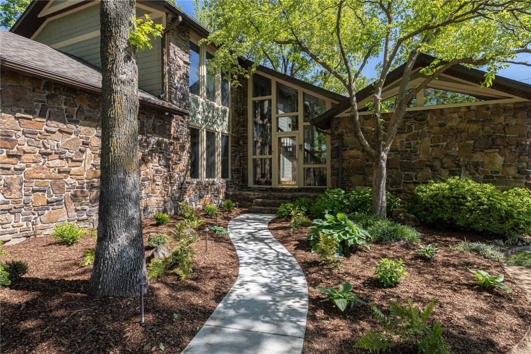 If you're looking for a one-of-a-kind home with a unique style then look no further! Step into this stunning home, complete with intricate stone exterior details & beautifully landscaped park-like lot with charming courtyards. You'll love the abundance of natural light that floods the space throughout with numerous windows. Features include hardwood floors, spacious floor plan, & office with private entrance. Kitchen opens to Living Room & features stainless appliances & pantry with LED accent lighting. Primary Suite has soaring ceilings, views of Lake Fayetteville, private bath with walk-in closets, walk-in shower with shimmering glass tiles, & access to private courtyard. Upstairs you'll find two bedrooms that share a bathroom, as well as a second primary suite with its own private balcony. Other features include partial home generator, 4 car garage that is wired for electric vehicles, NEW roof in 2022, & all appliances convey. Come see for yourself why this home is the perfect place for your next adventure!
