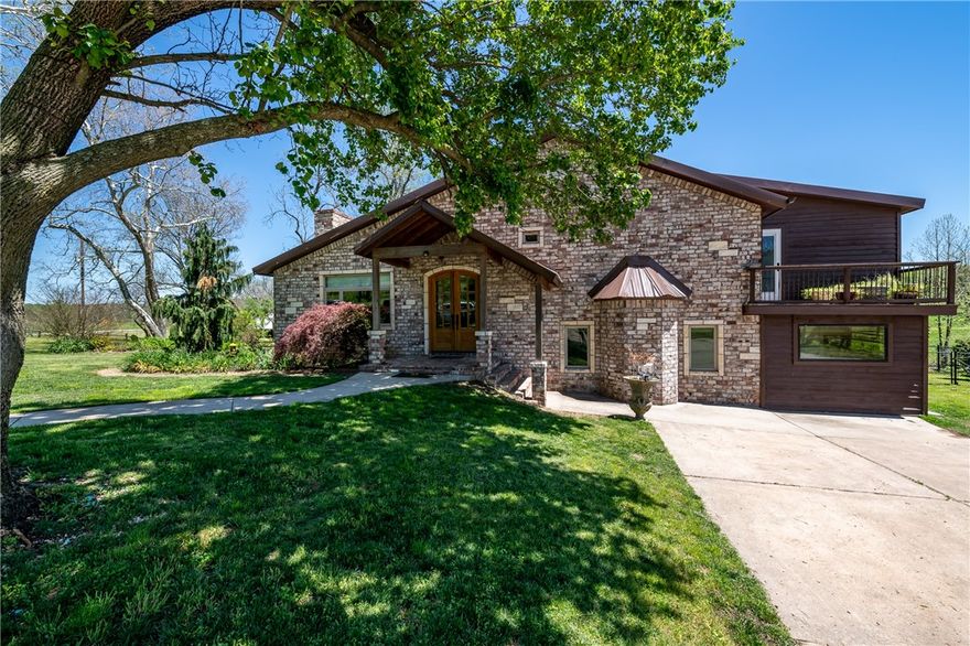 One of a kind property - 24.48 acres with custom built tri-level home, detached garage, three outbuildings, year-round creek, and a beautiful countryside. On the main road, less than 20 minutes to Bentonville. Builder owned and completely remodeled home that has been thoughtfully designed. Whole house, back-up generator.   Enjoy sitting in one of the many porch/deck areas, overlooking your personal valley and abundant wildlife. Newer 60x80 barn contains full living quarters (not included in listing specifications). 30x40 shop currently used as "man-cave". Approx. 47 more adjoining acres could be purchased.