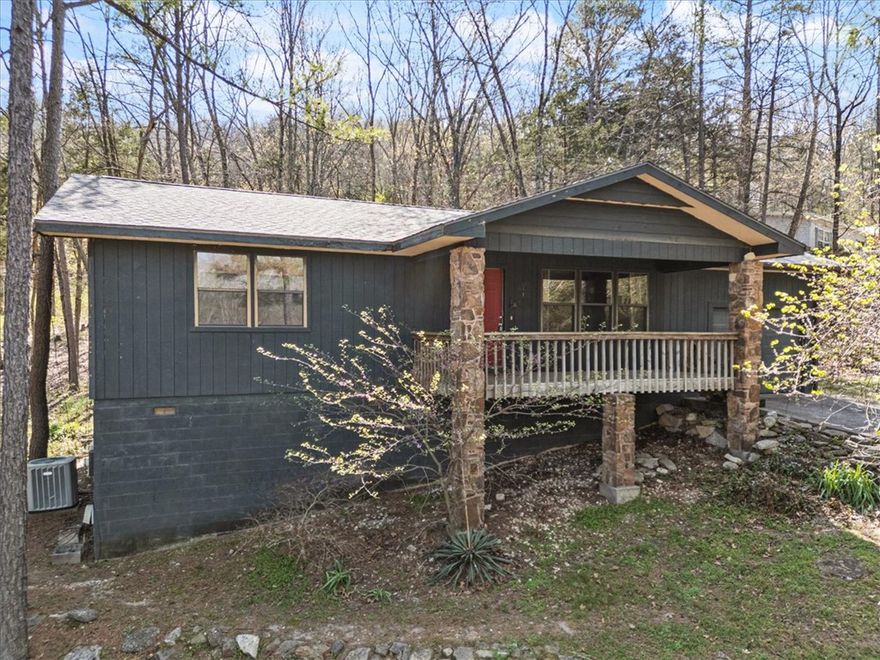 Nestled into the woods on a quiet side street in Holiday Island. You will simply be able to exhale & relax into a new calm state of being. The interior has a gentle warmth about it, featuring solid hardwood floors, lovely natural stone wood burning fireplace and a large skylight in the living room. Open concept allows for easy flow from the kitchen to the dining and living room. Laundry room & a huge walk in pantry are definitely a bonus. Primary suite has en suite bathroom and there is a second updated full bath in the hallway. Both bedrooms have ample closet space complete with a custom cedar organizer. Brand new roof & the wood floors have been scheduled for refinishing. The dishwasher and garbage disposal are brand new as well. The Outdoor spaces of this home are so serene. There is a lovely elevated covered front porch that is just the perfect spot for bird watching. The 300 SQ FT covered back deck has a stunning view with a huge yard & a very nice tall wooden fence that will ensure ample safety and privacy.