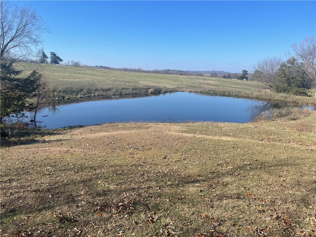 Don't miss this prime tract of land ready for your new home build! Mostly open, all useable 13.8 acres provides a country feel with room to breathe. Spring fed pond. Great access with county road frontage and short distance to pavement. Rural water, electric, fiber at road. Quick access to Hwy 412 and nearby amenities, 25 minutes to Fayetteville/Springdale. This scenic property combines an ideal out of town setting with convenience to necessities. Call for an appointment to take a look today! Utility availability is the responsibility of the buyer or buyers agent.