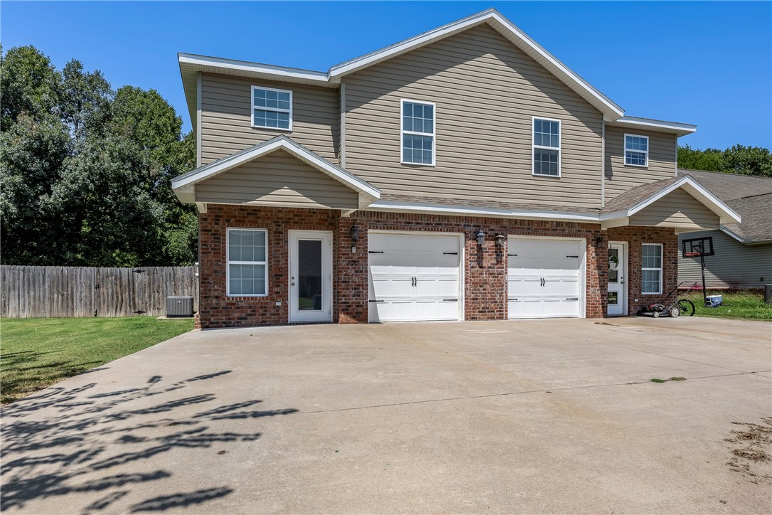 Traditional home featuring an attached garage, bri