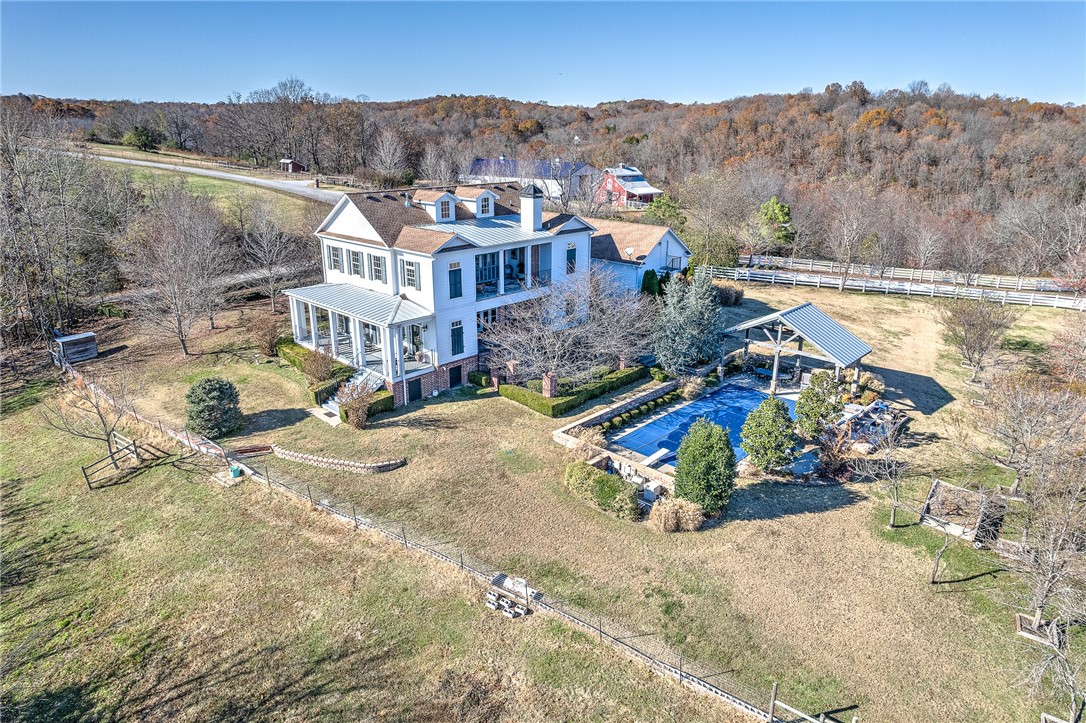 This elegant farm house is a Southern Living Idea Home. It is filled with gorgeous and abundant details including marble countertops, pine flooring and exquisite touches throughout. Spacious and cozy home, with access to lake front trail and your own inground pool. Home offers a riding arena, which could be converted into a tennis court, basketball court, or RV pad. Meticulous touches and pristine beauty, tucked in a private and beautiful setting!