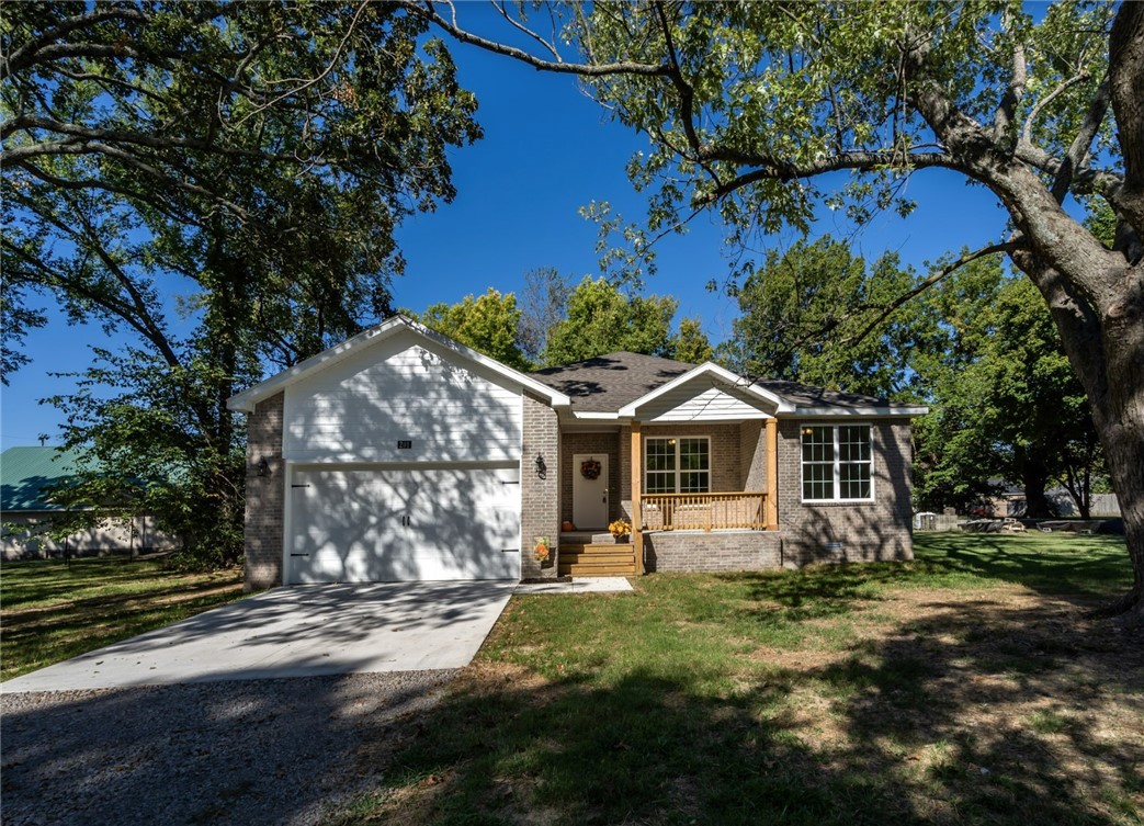 This all brick home is located on almost 3/4 of an acre and is surrounded by beautiful mature trees in a quiet established area of town. With 3 beds and 2 baths, the tall ceilings and extra attention to detail set this home apart from the rest. Plenty of can lighting and oversized windows keep things light and bright while the neutral tones and luxury vinyl plank flooring create a cozy feel. In the kitchen, the island is a showstopper in Sherwin Williams color of the year "Evergreen fog" and the upgraded appliances and gas range are ready to go to work. The cabinet hardware and other fixtures add to the well planned charm. Outside the large front porch welcomes you and the back deck is perfect for grilling and watching the kids, grandkids, or pups play. The spacious interior and beautifully done fireplace feels like home and is ready for all things fall. A 30x40 shop foundation is already in place for your future hobbies! Walk to the square, school or American Drive In. Come home to Lincoln! You'll love it!