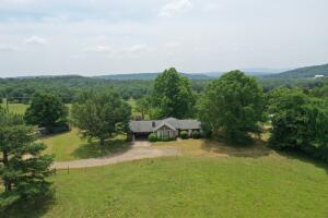Perched on a hillside you'll find this 1500sqft home with floor to ceiling windows and enclosed sunroom overlooking 10+/- acres with some of the most beautiful views of the River Valley. Pastureland, fenced and cross fenced, and shop.