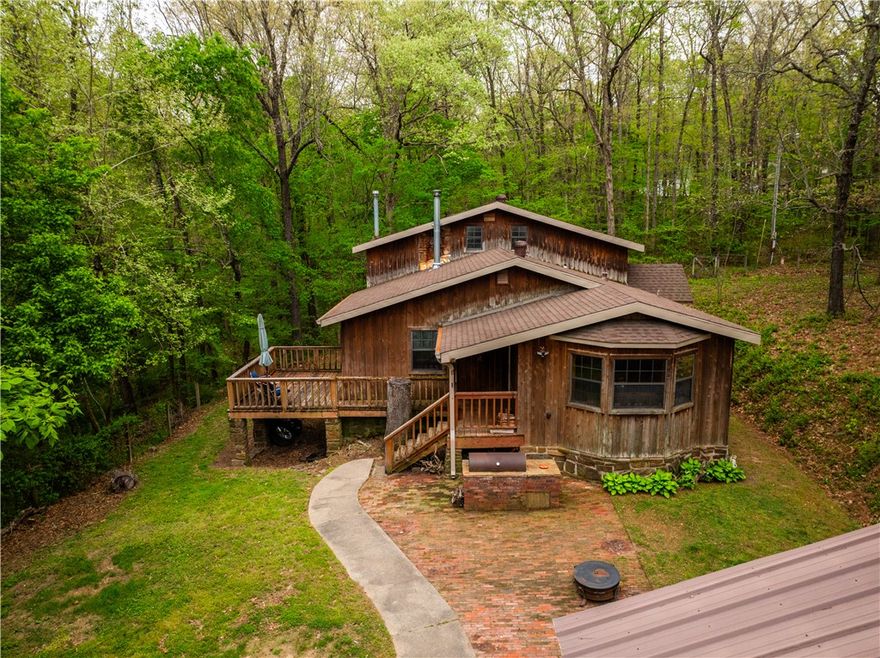 Spacious 5-bedroom, 2-bath home offering 2,116 sq ft on 2.17 acres of peaceful, tree-lined surroundings. Built with durable 2x6 exterior walls, this cedar home blends comfort, efficiency, and natural beauty. The open living area is filled with natural light and showcases scenic views of the surrounding landscape. Major updates include a new roof, gutters, and chimney in 2020, providing added peace of mind. Outside, you’ll find a detached 2-car garage and a metal carport, offering ample parking and storage options. Enjoy the outdoors from the patio with a built-in BBQ pit—perfect for entertaining, relaxing evenings, or weekend gatherings. The acreage provides privacy and plenty of space for gardening, recreation, or simply enjoying the quiet setting. A rare combination of space, functionality, and privacy—this property is ready to welcome you home. May not go FHA, RD or VA- Cosmetic repairs may be desired. Selling AS-IS