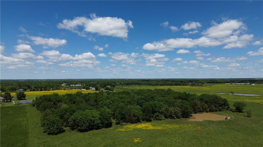 Round Prairie Near Gentry 26+ ACRES of level productive grassland with a small portion of wooded (an old orchard), 1 pond, fenced 3 sides, paved road!