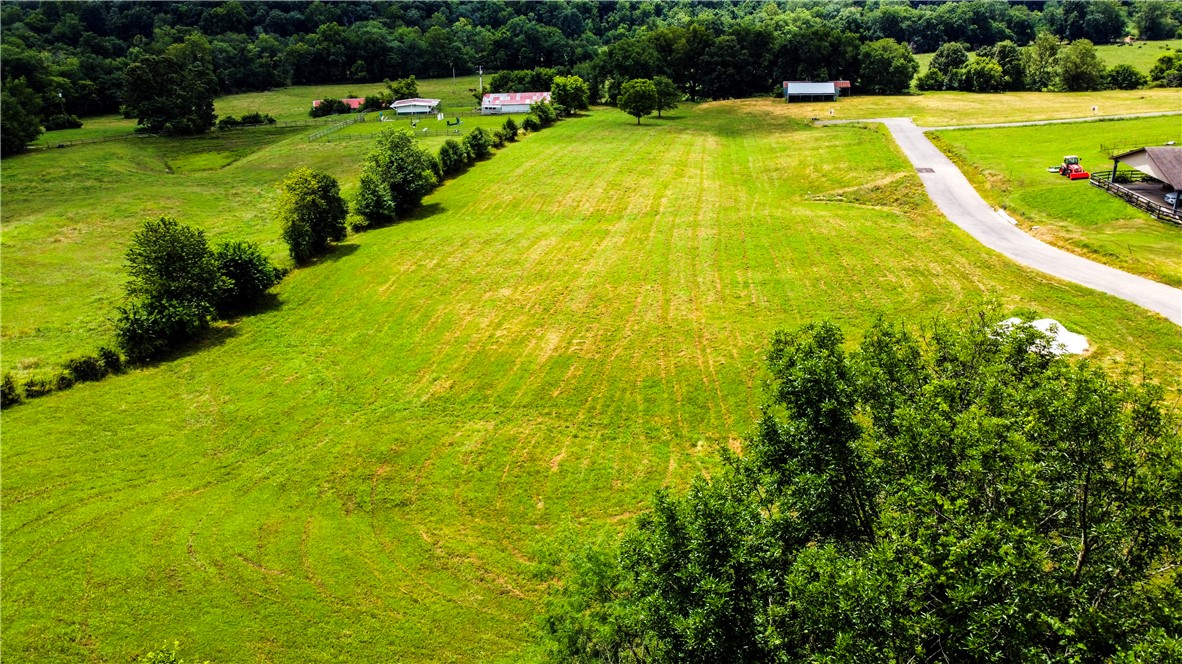 Gated community of 5 lots on a private drive + family friendly + 7 minutes from I-49 + 5 minutes from The Blessings + 3 minutes to 112 + Clear Creek access + convenience with a secluded feel + good schools + area of $1M+ homes... What more could you want in a lot on which to build your forever home? This exceptional lot offers the ultimate in luxury, privacy, and convenience. This 4.74 acre lot provides ample space while enjoying the benefits of a family-friendly neighborhood. It even backs up to the spring-fed Clear Creek! All utilities are present - including water, electric, natural gas, and fiber optic internet. Come build your dream home on one of these premier Reed Valley Estate lots located in one of NWA's most beautiful areas! (The house next door at 573 Reed Valley will undergo a complete remodel in starting in October).