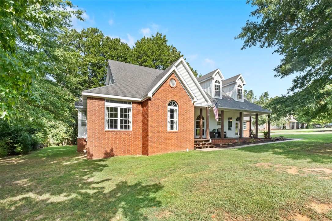 Step into this stunning 4 bedroom, 3 bathroom farmhouse-style home nestled on 2.2 sprawling acres with a 2-car attached garage. The property features enchanting wrap-around porches perfect for serene morning coffees or peaceful evening relaxations. Inside, discover a beautiful tiled master shower and a Jacuzzi-style tub, alongside meticulously kept interiors that include a formal dining area and a spacious eat-in kitchen. Additional amenities include a 576 sqft detached garage/workshop/mancave with extra storage upstairs. The expansive flat front yard offers ample space for activities, while the private, secluded backyard creates an oasis surrounded by large mature trees and lush bushes. Located just 5 minutes from Hwy 49, Wedington, and local public schools, and only 10 minutes to Razorback Stadium, this home combines the tranquility of country living with the convenience of city proximity. Ideal for families seeking a blend of comfort and elegance in a picturesque setting. Buyers, ask your agent for drone video!