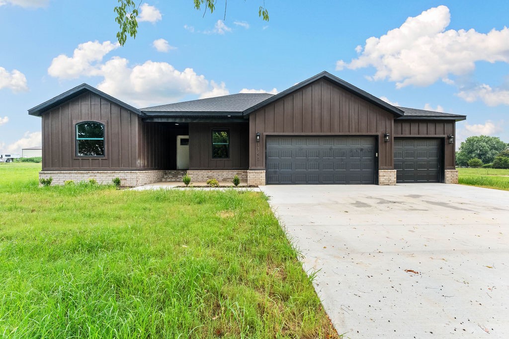 Modern Elegance Meets Country Living in this stunning new construction on a full 1-acre lot. Featuring 4 spacious bedrooms, a game room, and a 3-car garage. Thoughtfully designed with custom cabinetry, detailed trim work, and designer finishes, beautiful natural light, LVP flooring, and a striking feature wall in the living area. The kitchen impresses with quartz countertops, a large island, and a walk-in pantry, while the spa-like primary bathroom offers a freestanding tub, dual vanities, and bold tile accents. Every space—from the game room to utility areas—reflects quality craftsmanship. Set on a level lot with room to entertain, build a shop, or simply enjoy open space, the property also benefits from a newly paved road and a developing subdivision to the east, enhancing both value and community. Just minutes from downtown Bentonville, this is elevated country living at its best. Lower your interest rate with 7,500 concessions from the seller and up to 5,000 from preferred lender for a total of $12,500.